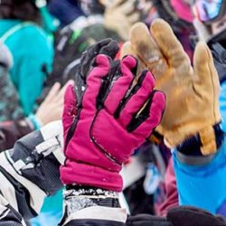 Two people in winter mountain gear high-fiving