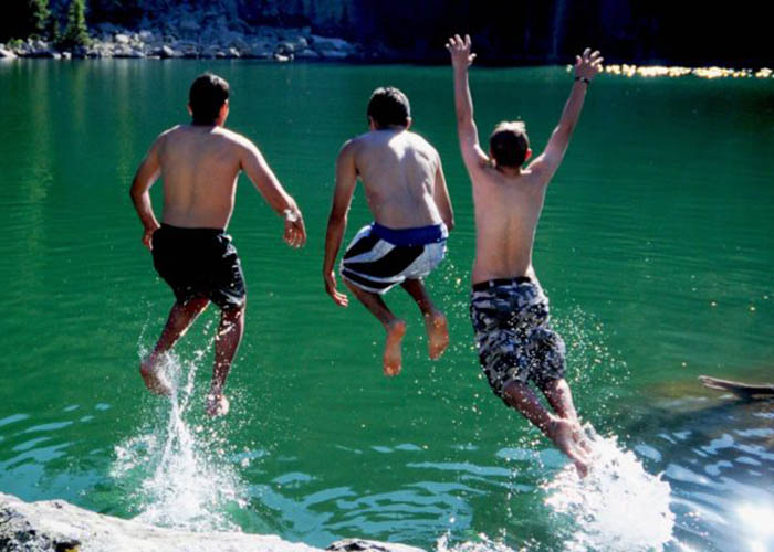 SOS Outreach youth jumping into the water during summer