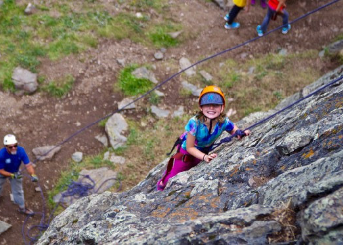 Girl rock climbing at Colorado Monument with SOS Outreach