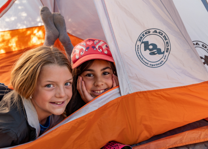 Two kids camping in a Big Agnes tent at an SOS Outreach event